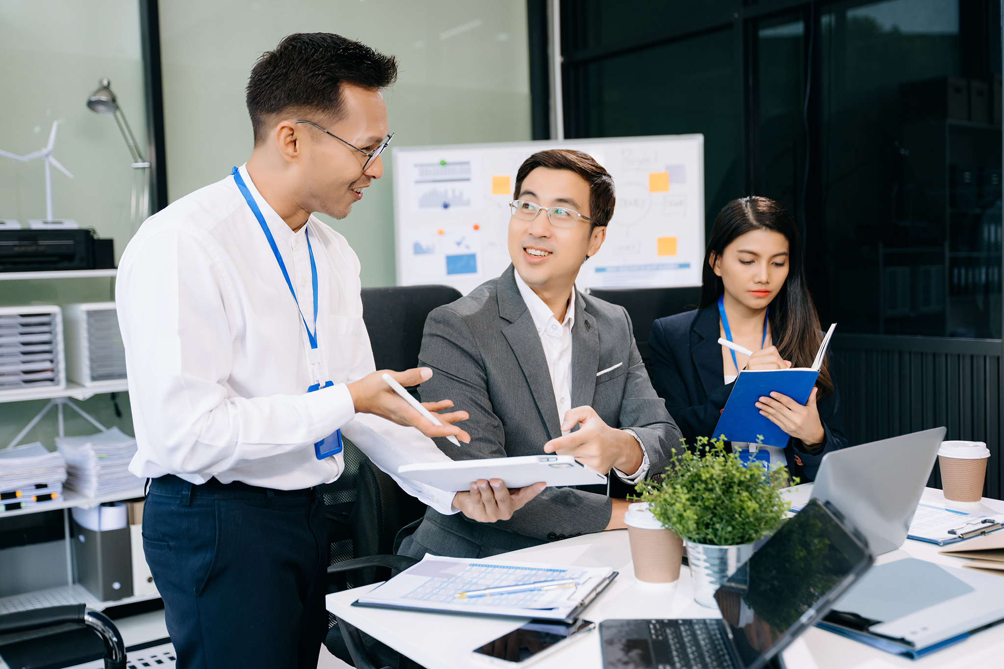 Office colleagues have a casual discussion. During a meeting in a conference room, a group of business teem sit in the conference room new startup project.